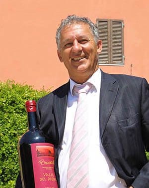 Giuseppe Brancatelli met een fles van zijn eigen Toscaanse wijn