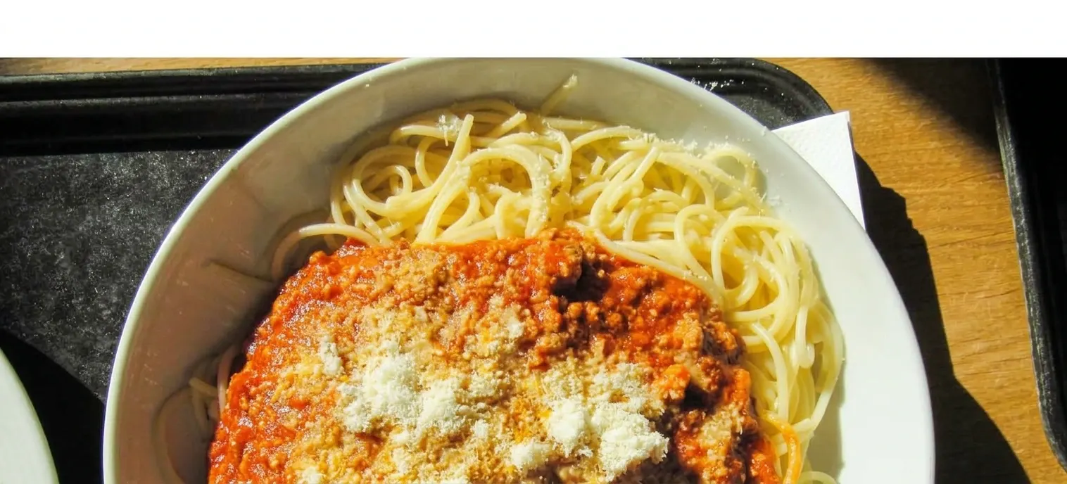 Spaghetti met tomatensaus, gehakt en geraspte Parmezaanse kaas